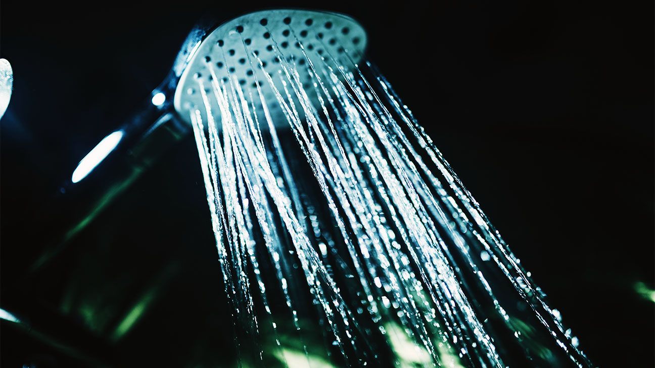 A shower that is on against a black background
