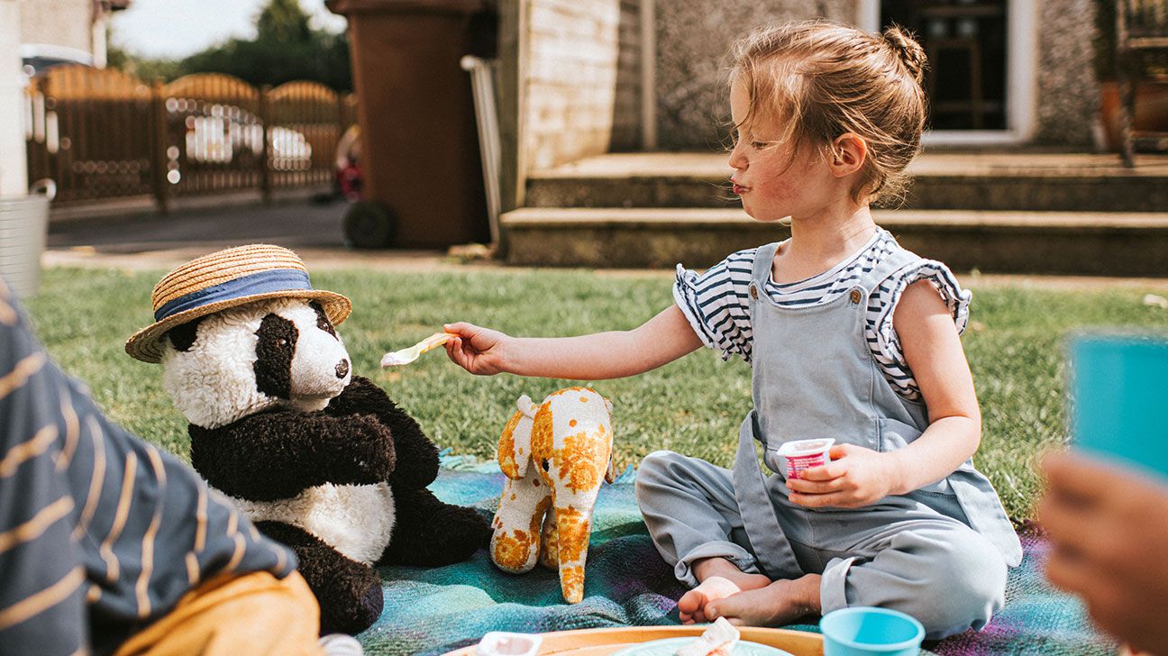 child pretending to share with a toy