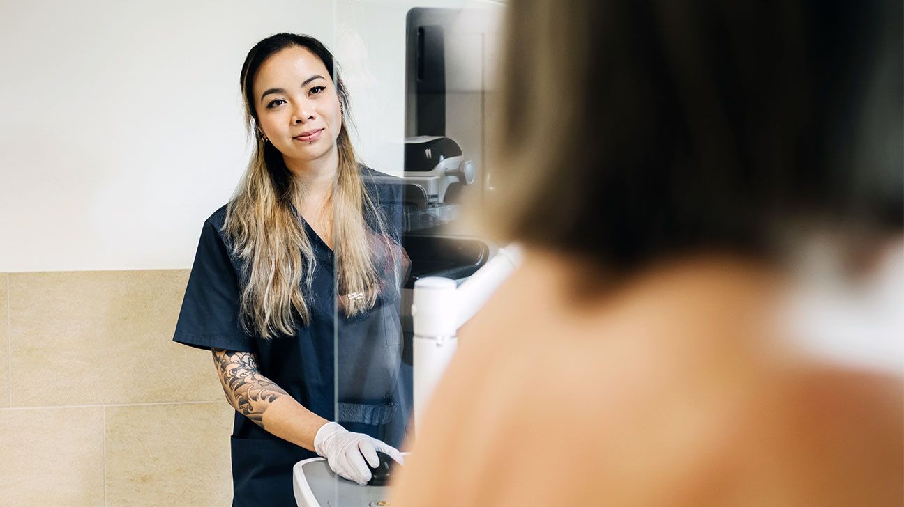 Female technician performs mammogram on patient