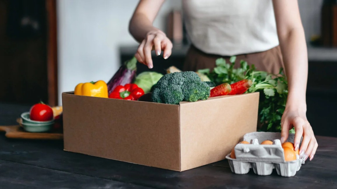 Woman taking produce out of her grocery delivery box
